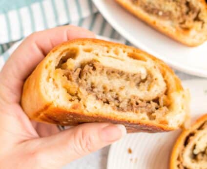 Sliced golden-brown Mozzarella Sausage Bread showing the savory filling swirl