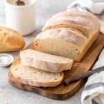 A stunning, golden italian bread recipe loaf on a wooden board.